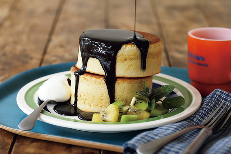 パンケーキにチョコレートソースをかけている