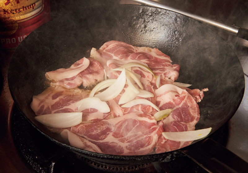 フライパンで豚肉を焼いている