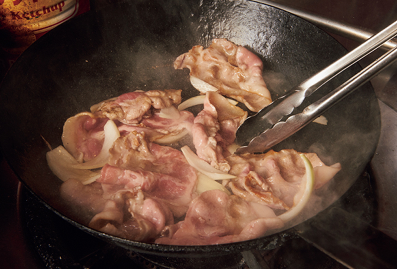 フライパンで豚肉を焼いている