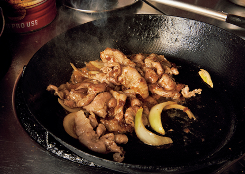 フライパンで豚肉を焼いている