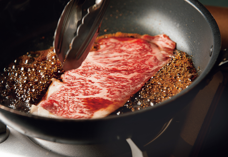 フライパンで肉を焼いている