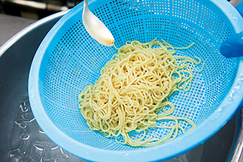 麺にごま油をかけている