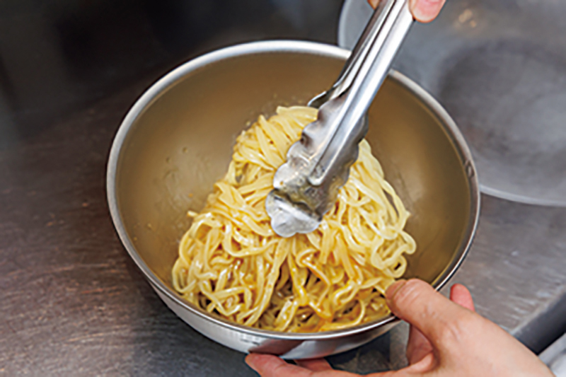 麺とたれを和えている