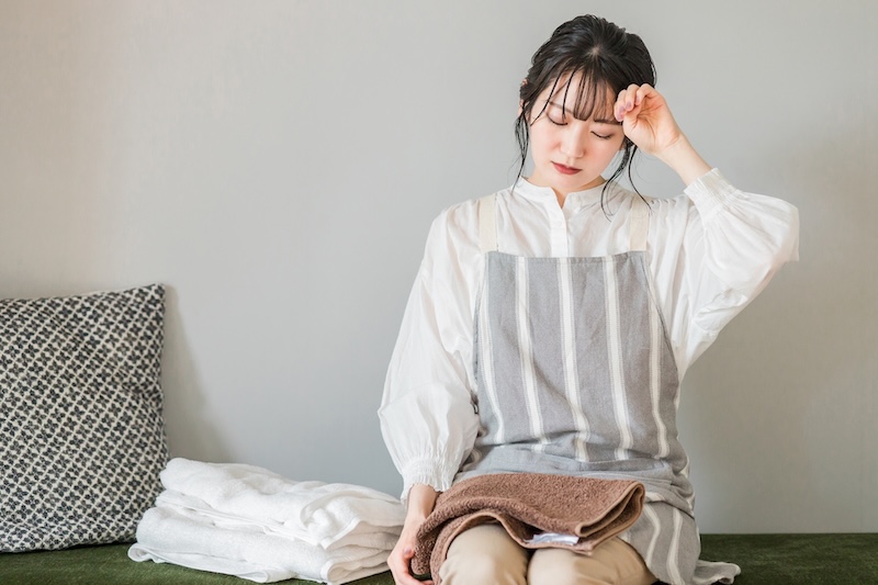 おでこに手を当てる女性