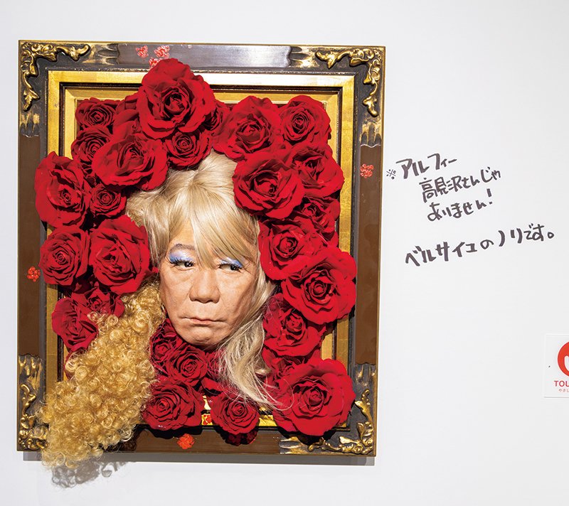赤いバラに囲まれた金髪の人物のアート