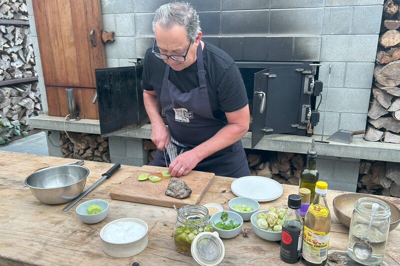 半屋外のおしゃれな調理場で。炙ったマグロに合わせるグリーンキウイをスライス