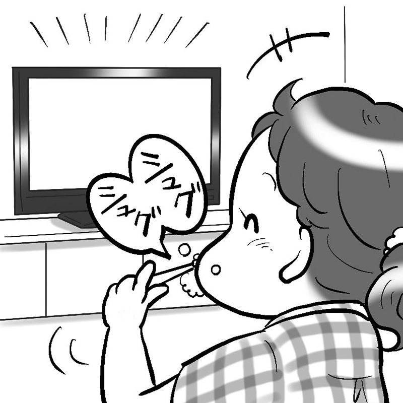 テレビを見ながら歯磨きをする女性