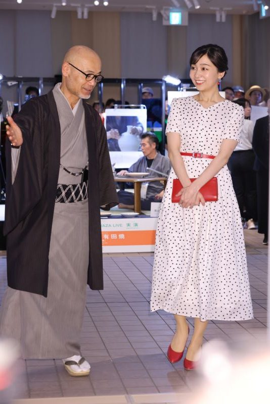 水玉のワンピースに赤いベルトと赤いバッグ。夏らしいコーディネートだ。