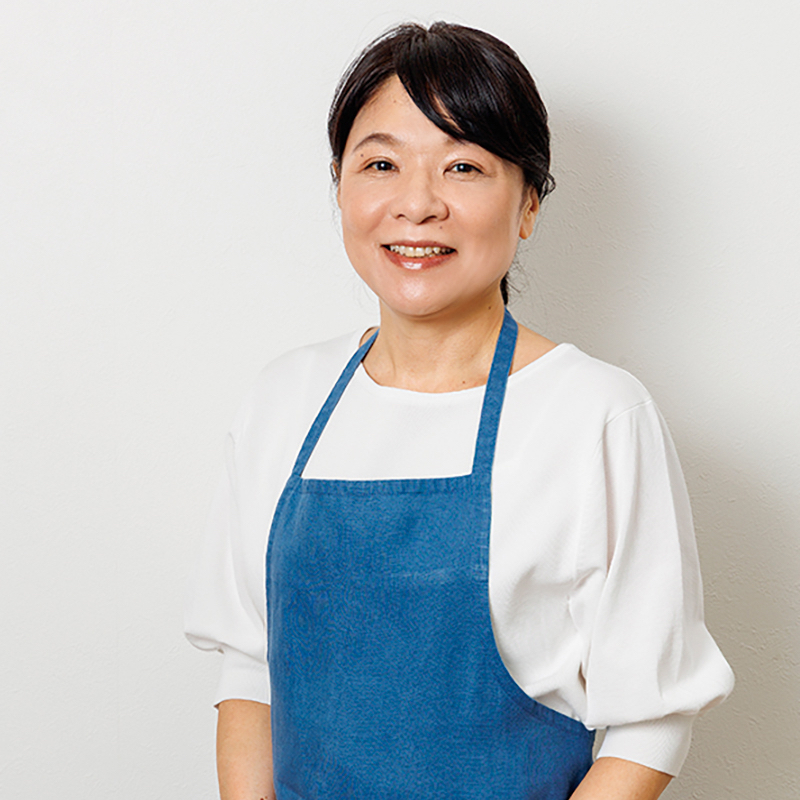 青いエプロンをした女性