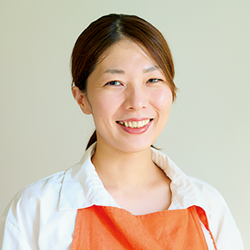オレンジ色のエプロンをした女性