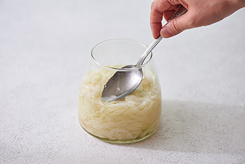 瓶の中身をスプーンで押している
