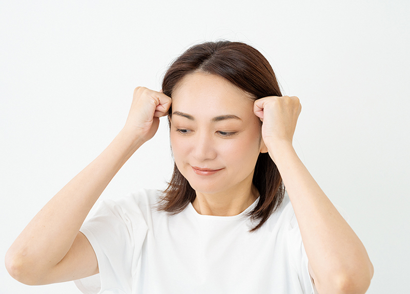 指の第二関節あたりをこめかみにあてて
