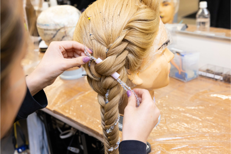 結った髪が絡まないよう、切った太いストローを使ってビーズのワイヤーを通していく