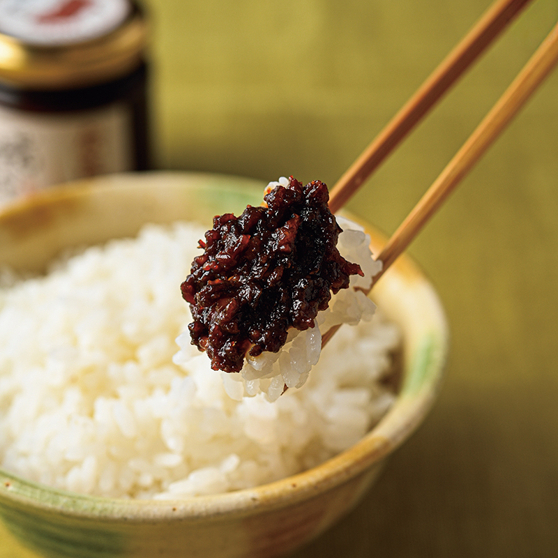 みそをのせたコメを箸で持ち上げている