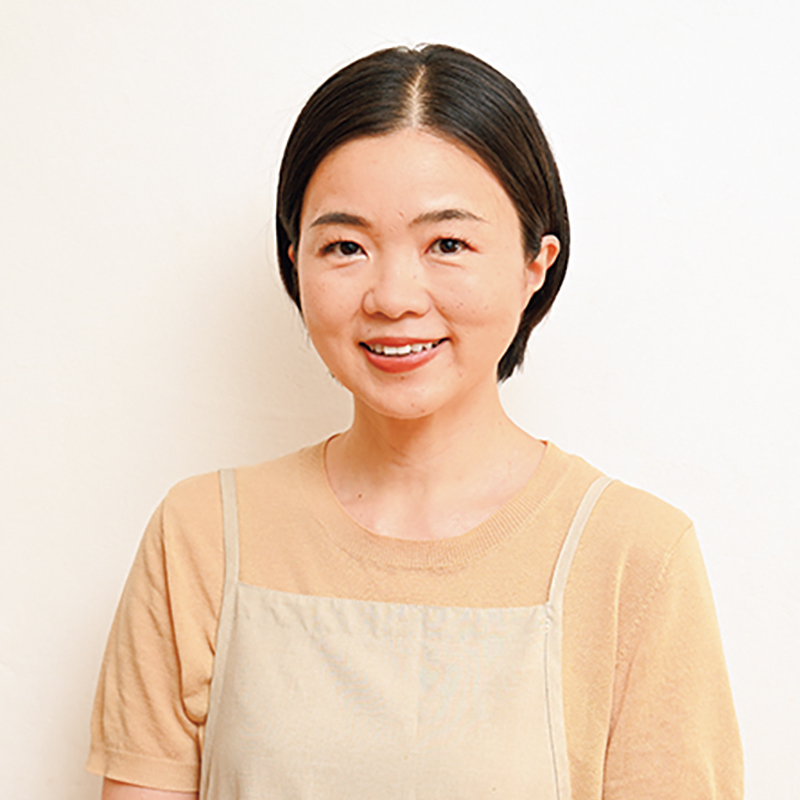 ベージュのエプロンをした女性