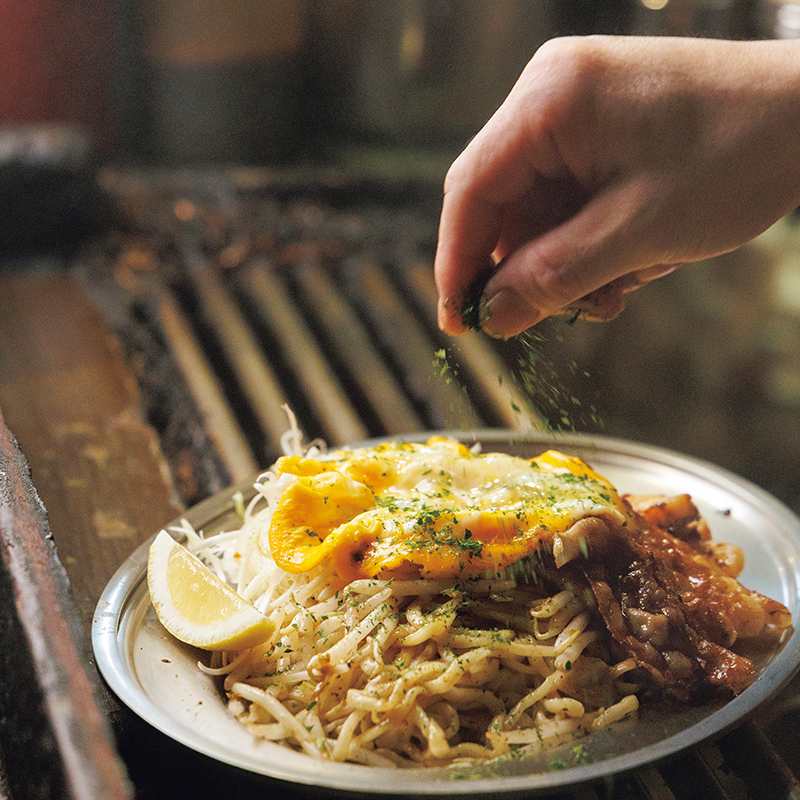 焼きそばに青のりをかけている