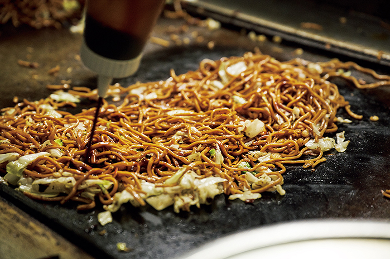 焼きそばにソースをかけている