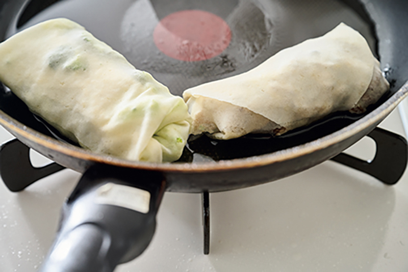 フライパンで春巻を焼いている
