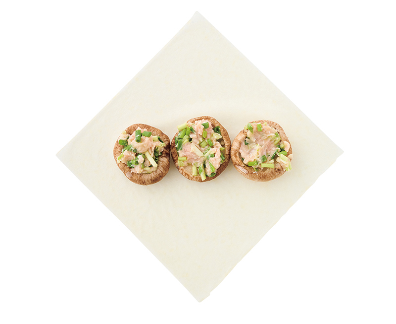 肉詰めにしたしいたけが春巻きの皮の上に並んでいる