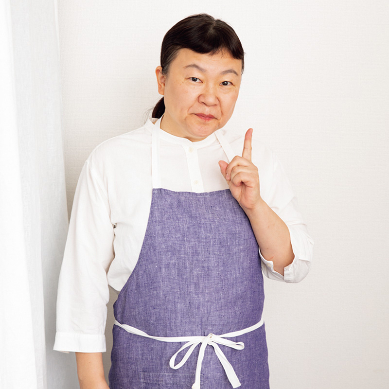 紫色のエプロンをした女性