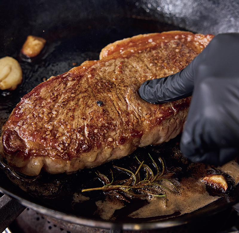 肉を押して焼き加減を確認（撮影／鈴木泰介）