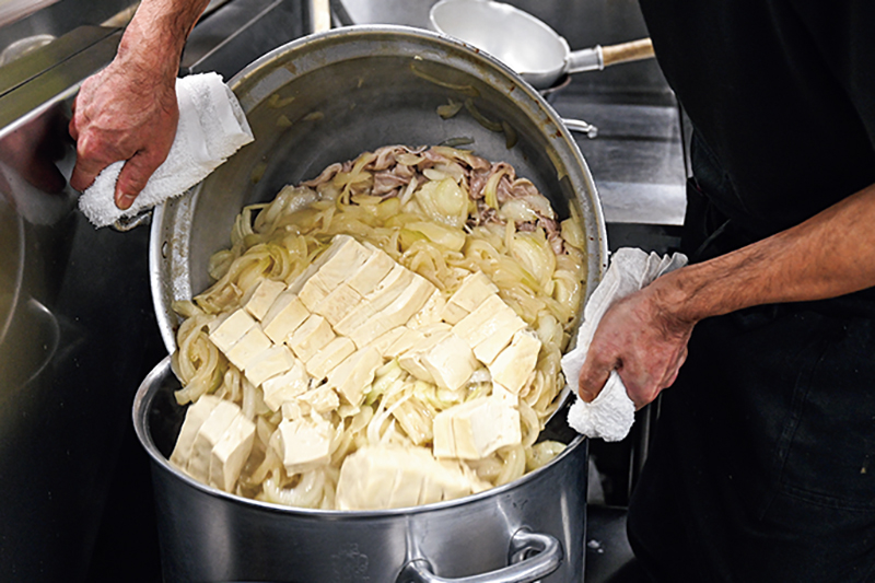 鍋の中身を移し替えている