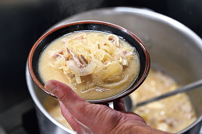 豚汁をよそっている