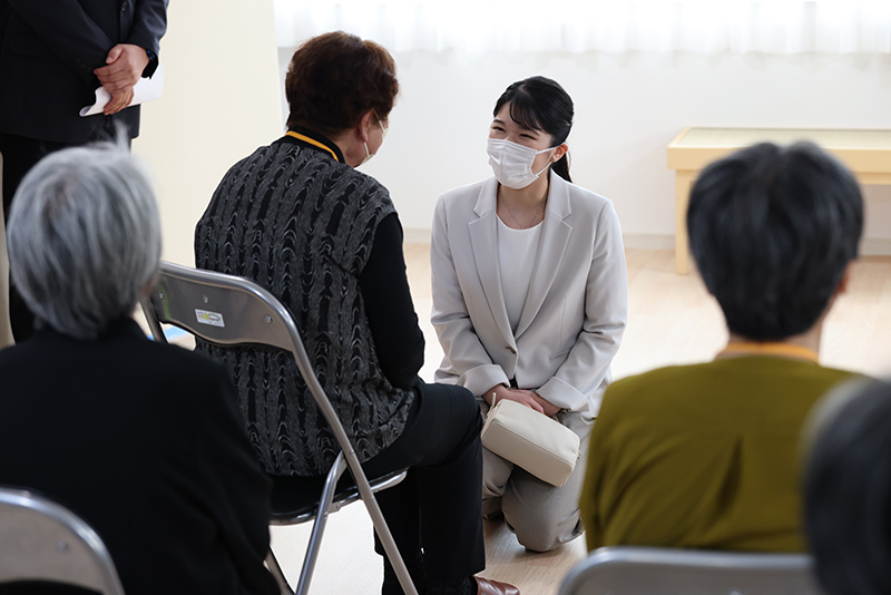 能登半島の仮設団地で、膝をついて被災者と交流される愛子さま（2025年5月、石川県七尾市。撮影／JMPA）