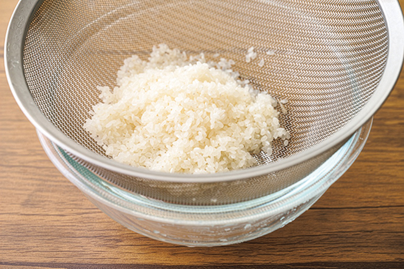 ざるにあげて米の水気を切る