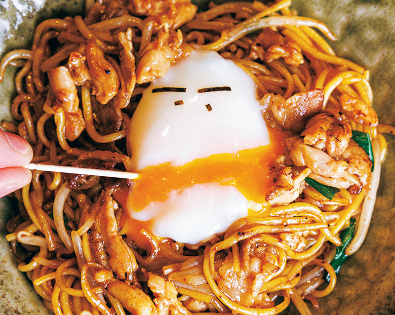半熟卵を割ると口から黄身が流れ出す『とりせせり焼きそば』（1100円）。「この遊び心は大阪ならでは！」（遠藤さん）。「サステナブルにギャグを掛け合わせるセンスがかっこいい」（見冨さん）