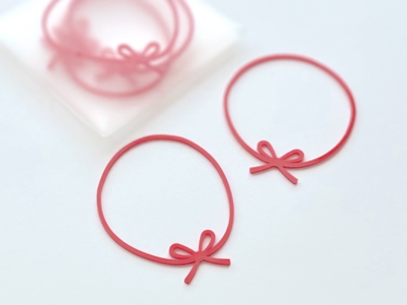 カラフルな輪ゴムに、蝶結びのモチーフが付いたシンプルなデザイン。半透明なケース入りで持ち運びやすい