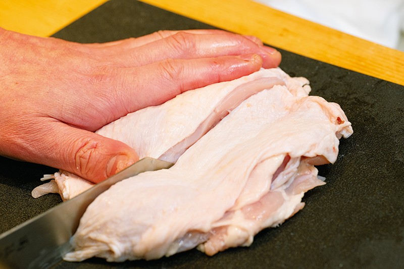 皮をよく伸ばしてから縦半分に切ると切り分けやすい。「皮目を上にすると皮がよれず、皮も均一に切りやすい」