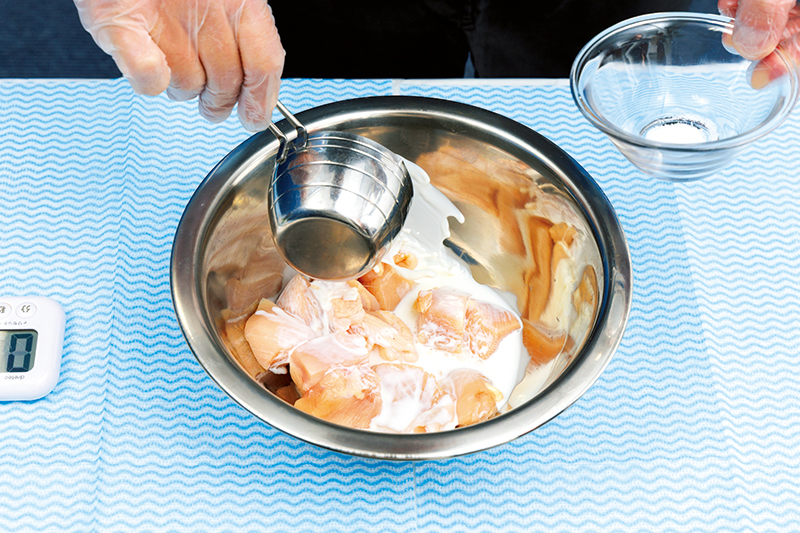 鶏肉に牛乳と塩を加えたら、高速で回転させながら鶏肉に牛乳を揉み込む