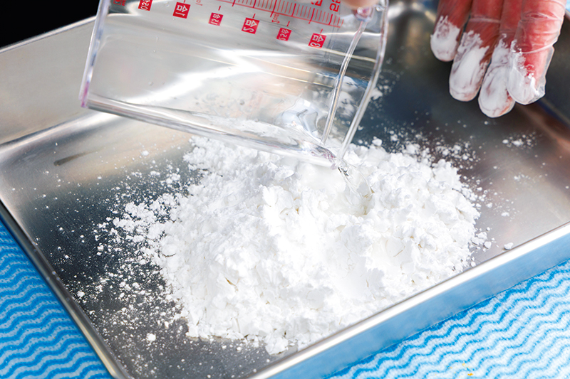 片栗粉に水を混ぜ、両手で粉をこすり合わせて小さなダマを作る