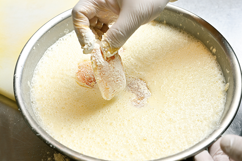 「お店では数種類の粉を配合していますが、家庭では天ぷら粉を使うと手軽」。肉に打ち粉をした後、揚げる直前に揚げ衣にくぐらせる