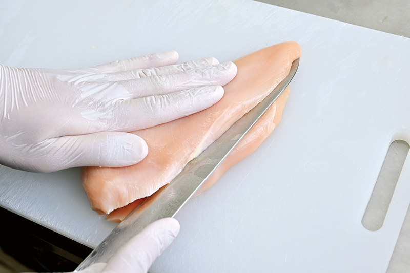 鶏胸肉が直角三角形になるように、斜め下に包丁を入れて青囲み部分を切り落とす