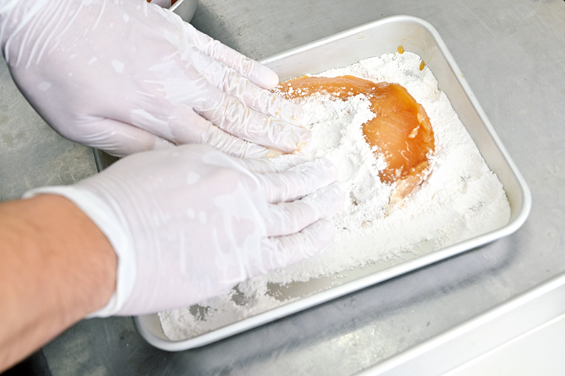 「肉に粉を入れ込むつもりで上から押して衣をつけます