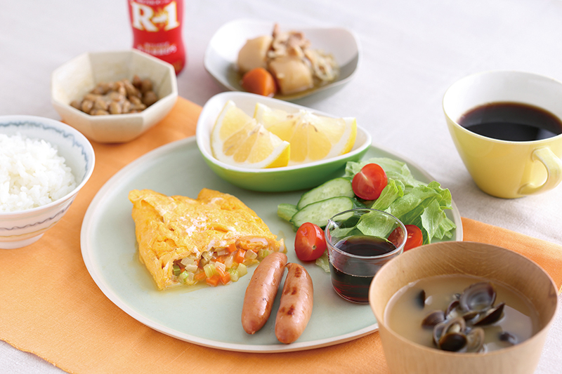 みじん切りにした玉ねぎとにんじんを軽く炒めて、卵3個を使ったオムレツの具に。メニュー構成はほぼ固定しているが、前夜のおかず（今朝は肉じゃが）を少し加えて変化をつけている。添え野菜にはポン酢をかけて。