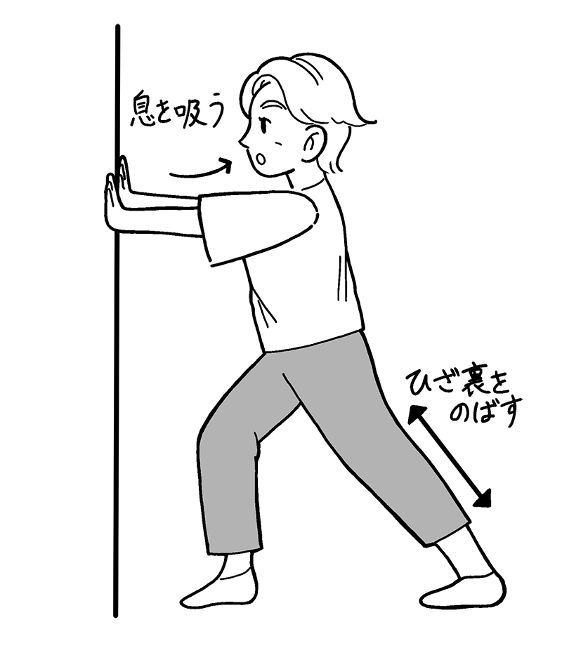 足を前後に開いて両手を伸ばして壁につく（イラスト／sashimi）