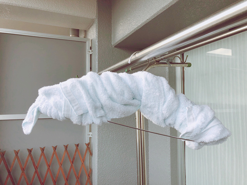 薄いハンガーでは、水の重みで肩部分に負担がかかり型崩れするので、タオルで厚くする