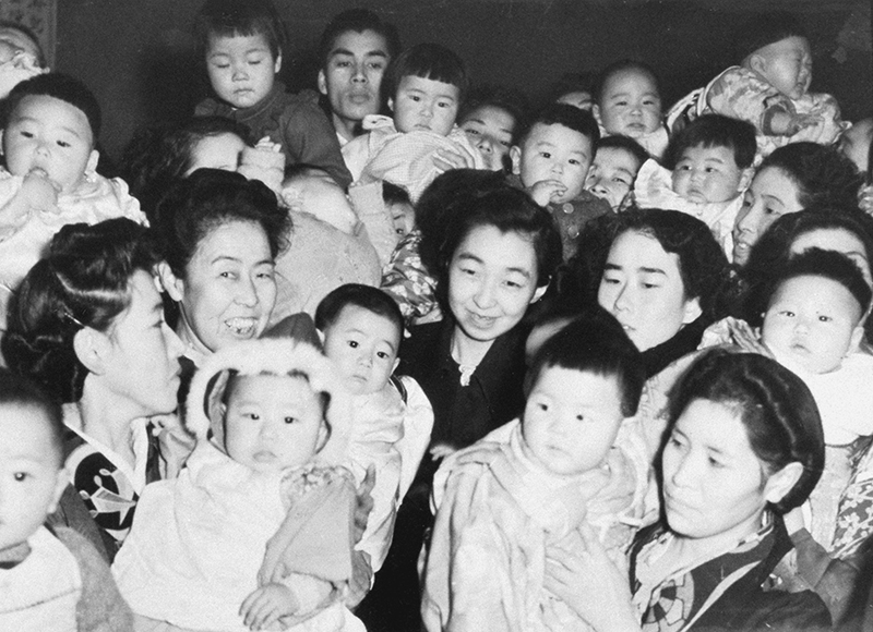 「優良乳幼児表彰式」に出席し、大勢の子供たちに囲まれる東久邇成子さん（中央）（1949年12月、東京・台東区。写真／共同通信社）