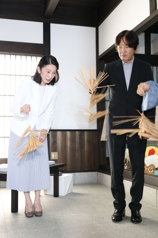 吹田扇子を手に取られる秋篠宮ご夫妻。紀子さまは白を基調としたコーデ。（2026年8月、写真／JMPA）