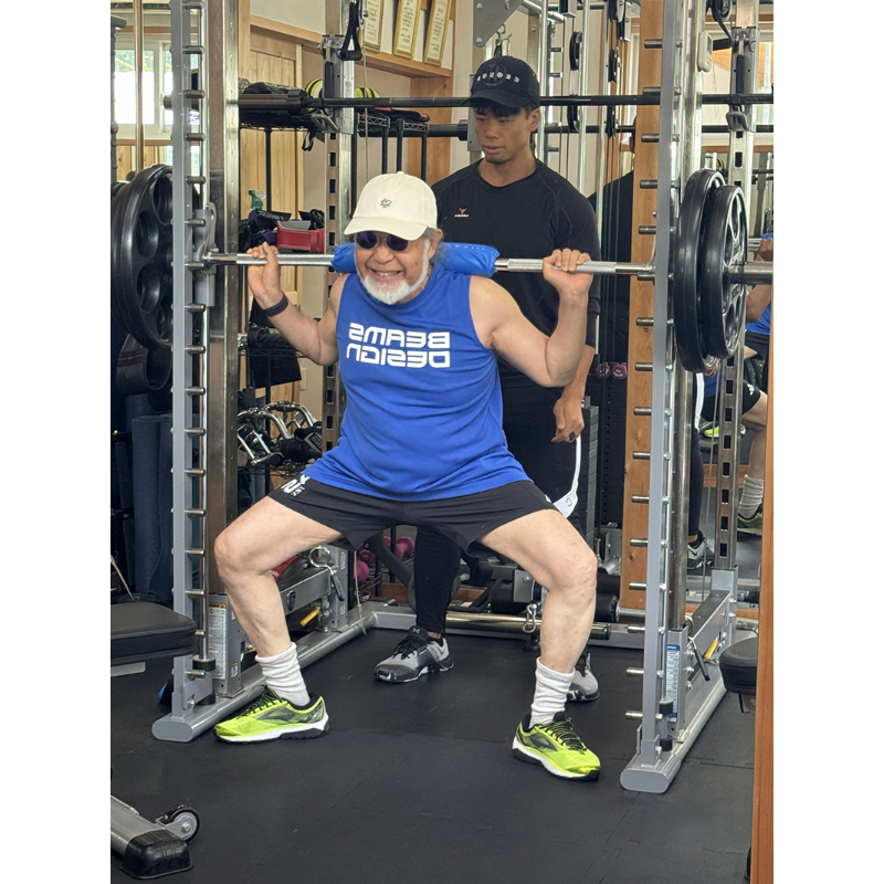 90kgのバーベルを担ぎ、ワイドスクワットをする鎌田さん
