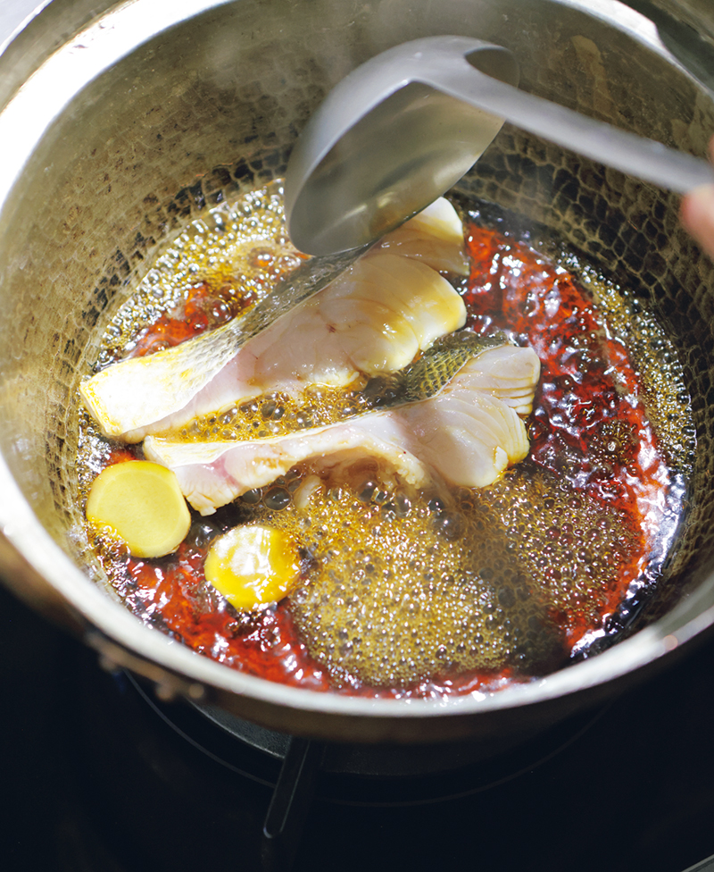 切り身魚を煮汁に入れたら、上からも煮汁をかけて煮る。「魚を煮るときはしょうがが必須。生ぐさみが消え、キリッとした味に仕上がります」。
