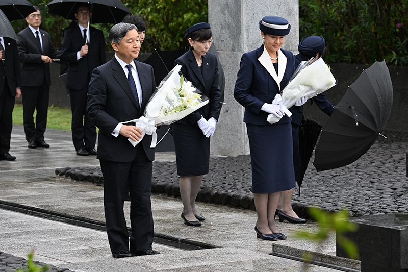 雨の中、慰霊碑に祈りを捧げられる両陛下（2025年4月、東京・小笠原村。撮影／JMPA）