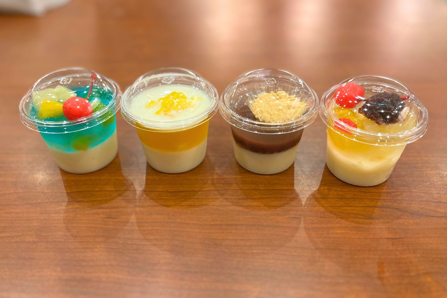 初のひんやりスイーツが登場！左から、「丸亀うどんプリン ブルーハワイ」340円、「丸亀うどんプリン マンゴー」290円、「丸亀うどんプリン あんきなこ」290円、「丸亀うどんプリン あんみつ風」340円（いずれも税込）