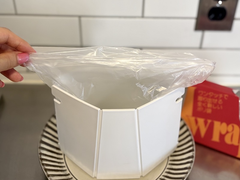 袋の口をたたみ…