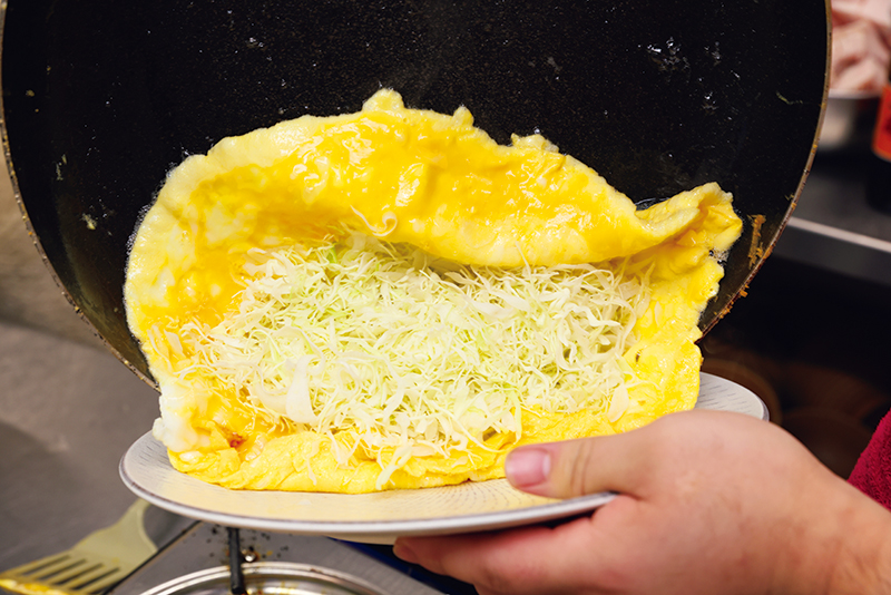 味付けをしていない薄焼き卵で、キャベツのせん切りを包む。ソース、マヨネーズ、青のり、かつおぶしでお好み焼き風に。