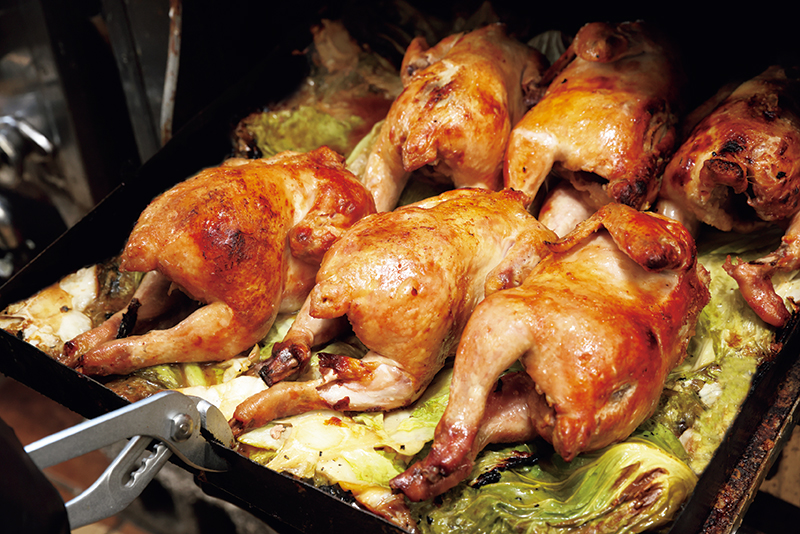 『自家製ローストチキン』（1900円/要予約）は国産若鶏を使用。1羽ずつ焼き色を見ながらじっくり焼く。旨みがのった身は驚くほどしっとり！（撮影／玉井幹郎）