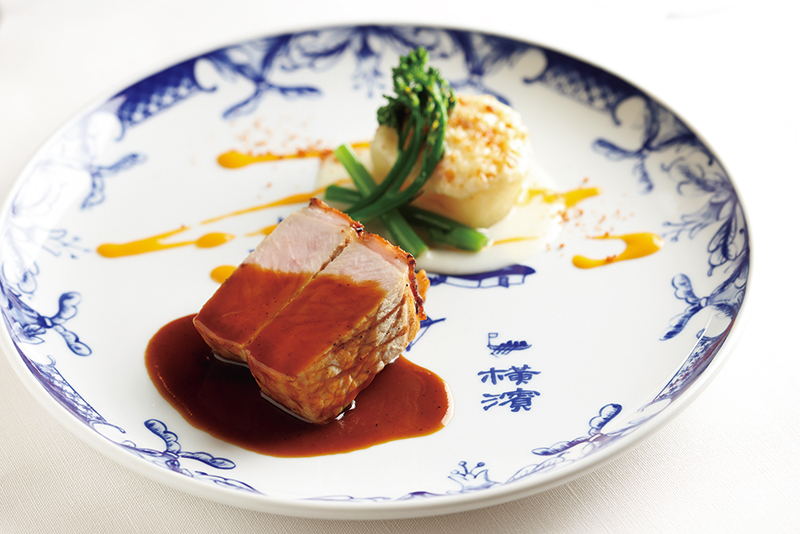 『ランチコース』（6600円／別途サービス料10%）。横浜のブランド豚「やまゆりポーク」のグリルは、ウッディーな香りのねずの実のソースがアクセント。横浜焼の器との組み合わせも上品（撮影／菅井淳子）